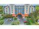 Multi-story condo complex featuring balconies and a covered entrance, surrounded by lush greenery and landscaping at 5300 S Atlantic Ave # 16-205, New Smyrna Beach, FL 32169