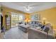 Bright living room with a large sectional sofa, a ceiling fan, and sliding glass doors to the balcony at 5300 S Atlantic Ave # 16-205, New Smyrna Beach, FL 32169