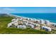 Expansive aerial view of a beachfront condo community with ocean views, lush greenery, and easy beach access at 5300 S Atlantic Ave # 20-507, New Smyrna Beach, FL 32169