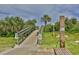 Convenient beach access with a wooden boardwalk, outdoor shower, and signage ensuring a pleasant and compliant beach experience at 5300 S Atlantic Ave # 20-507, New Smyrna Beach, FL 32169