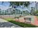 Community tennis and shuffleboard courts are fenced and surrounded by lush landscaping, benches, and convenient parking at 5300 S Atlantic Ave # 20-507, New Smyrna Beach, FL 32169