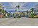 Gated community entrance with decorative archway, palm trees, and 'Sales Office Open' sign, offering a welcoming atmosphere at 5300 S Atlantic Ave # 20-507, New Smyrna Beach, FL 32169