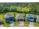 Aerial view of three homes surrounded by lush greenery, ponds and mature trees at 5607 Estero Loop, Port Orange, FL 32128