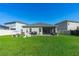Expansive lawn with a screened porch, patio, play equipment, and fenced yard at 5607 Estero Loop, Port Orange, FL 32128