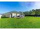 Large backyard with lush lawn, patio, play equipment, and privacy fence at 5607 Estero Loop, Port Orange, FL 32128