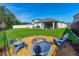 Serene backyard with a fire pit area surrounded by Adirondack chairs and lush greenery at 5607 Estero Loop, Port Orange, FL 32128