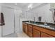 Bright bathroom featuring granite counters, double sinks, dark wood cabinetry, and a glass shower enclosure at 5607 Estero Loop, Port Orange, FL 32128