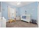 Stylish bedroom features chair, crib and light blue cloud-themed wallpaper and white trim at 5607 Estero Loop, Port Orange, FL 32128