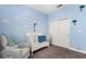 Well-lit bedroom with a crib, cloud-themed wallpaper and double door closet at 5607 Estero Loop, Port Orange, FL 32128