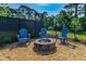 Cozy fire pit area with gravel, stone surround, and three Adirondack chairs at 5607 Estero Loop, Port Orange, FL 32128