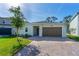Charming home with beautiful landscaping, a two-car garage, and a brick paver driveway at 5607 Estero Loop, Port Orange, FL 32128