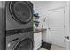 Well-equipped laundry room with front load washer, dryer and storage shelves at 5607 Estero Loop, Port Orange, FL 32128