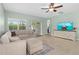 Living room with tiled floors, modern decor, sliding glass doors to a patio, and a ceiling fan at 5607 Estero Loop, Port Orange, FL 32128
