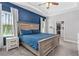 Serene main bedroom boasts tray ceiling, plush carpet, blue accent wall, and a spacious walk-in closet at 5607 Estero Loop, Port Orange, FL 32128