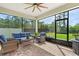 Inviting screened patio featuring brick pavers, ceiling fan, and comfortable wicker furniture with a view of the landscaped backyard at 5607 Estero Loop, Port Orange, FL 32128