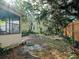 Backyard with brick accents, lush greenery, and a glimpse of a charming yellow house at 600 Magnolia St, New Smyrna Beach, FL 32168