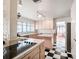 Bright kitchen with black and white checkerboard floors, an island, and a pass through to another room at 600 Magnolia St, New Smyrna Beach, FL 32168