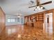 Spacious living room featuring wood paneled walls, parquet flooring, and built in shelves at 600 Magnolia St, New Smyrna Beach, FL 32168