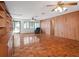 Large living room featuring wood paneled walls, parquet flooring, and built in shelves at 600 Magnolia St, New Smyrna Beach, FL 32168
