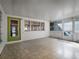 Enclosed sunroom with tiled floors, white brick walls, and windows for a sun-filled interior at 600 Magnolia St, New Smyrna Beach, FL 32168