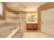 Spacious bathroom featuring a large tub, glass shower, and vanity with ample lighting at 6093 Sabal Creek Blvd, Port Orange, FL 32128