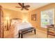 Well-lit bedroom with a ceiling fan, plush bedding, and a sitting bench at 6093 Sabal Creek Blvd, Port Orange, FL 32128