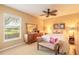 Cozy bedroom featuring a comfortable bed, dresser, and a window with a serene outdoor view at 6093 Sabal Creek Blvd, Port Orange, FL 32128