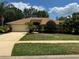 Well-maintained single-story home featuring lush landscaping, mature trees, and a manicured lawn at 6093 Sabal Creek Blvd, Port Orange, FL 32128