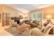 Inviting living room featuring a cozy fireplace, comfortable seating, and a large window with natural light at 6093 Sabal Creek Blvd, Port Orange, FL 32128