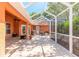 Screened-in patio with brick flooring, an outdoor seating area, and a ceiling fan, perfect for enjoying the outdoors at 6093 Sabal Creek Blvd, Port Orange, FL 32128