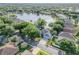 Aerial view of a single-Gathering home near a beautiful lake, surrounded by lush trees and well-manicured lawns at 634 Woodford Dr, Debary, FL 32713