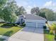 Aerial view of a single-story home with mature trees, a three-car garage and lush landscaping at 634 Woodford Dr, Debary, FL 32713