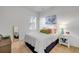 Bright bedroom showcasing a bed with white comforter, neutral walls, and a decorative painting at 634 Woodford Dr, Debary, FL 32713