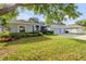 A well-maintained single story home with a three car garage, lush lawn, and mature trees at 634 Woodford Dr, Debary, FL 32713