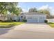 A well-maintained single story home with a three car garage, lush lawn, and mature trees at 634 Woodford Dr, Debary, FL 32713