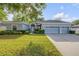 Charming single-story home featuring a three-car garage, manicured lawn, and a welcoming front entrance at 634 Woodford Dr, Debary, FL 32713