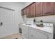 Laundry room features a white washer and dryer, with upper wood cabinets at 634 Woodford Dr, Debary, FL 32713
