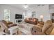 Living room with fireplace, ceiling fan, comfortable seating and large windows at 634 Woodford Dr, Debary, FL 32713