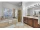 Bright bathroom features a large soaking tub, glass shower and a double sink vanity at 634 Woodford Dr, Debary, FL 32713