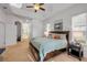 Bright main bedroom featuring a tray ceiling, ceiling fan and neutral walls and carpet at 634 Woodford Dr, Debary, FL 32713