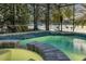 Screened-in pool with waterfall feature overlooking the lake at 634 Woodford Dr, Debary, FL 32713