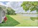 Spacious backyard with manicured lawn, landscaping, and a tranquil pond view at 6403 Adrianne Ct, Port Orange, FL 32128