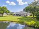 Picturesque backyard with a pond view, mature trees, and a well-maintained lawn at 6403 Adrianne Ct, Port Orange, FL 32128