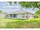 Well-maintained backyard with lush green grass, screened lanai, and mature landscaping at 6403 Adrianne Ct, Port Orange, FL 32128
