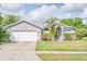 Charming single-story home featuring a well-manicured lawn, stucco exterior, and a two-car garage at 6403 Adrianne Ct, Port Orange, FL 32128