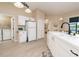Kitchen with white cabinets and appliances, pantry access and an open view of the yard at 6403 Adrianne Ct, Port Orange, FL 32128