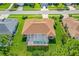 Aerial view showcasing a home with an outdoor pool and screened-in lanai on a large green lot at 6436 Longlake Dr, Port Orange, FL 32128