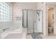 Bright bathroom featuring a tiled shower, soaking tub, and floral wallpaper accents at 6436 Longlake Dr, Port Orange, FL 32128