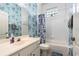 Inviting bathroom with a vanity, toilet, shower with a curtain, and a glass block window at 6436 Longlake Dr, Port Orange, FL 32128