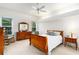Bright bedroom features tray ceiling, plush carpet, natural light from two windows, and wooden furniture at 6436 Longlake Dr, Port Orange, FL 32128